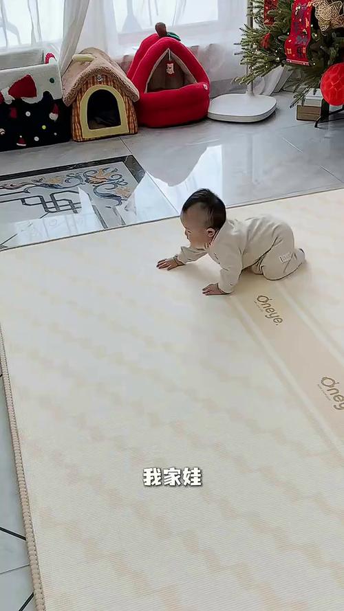 妈妈蹲在爬爬垫旁举着两件儿童外套给2岁宝宝做选择的实拍图