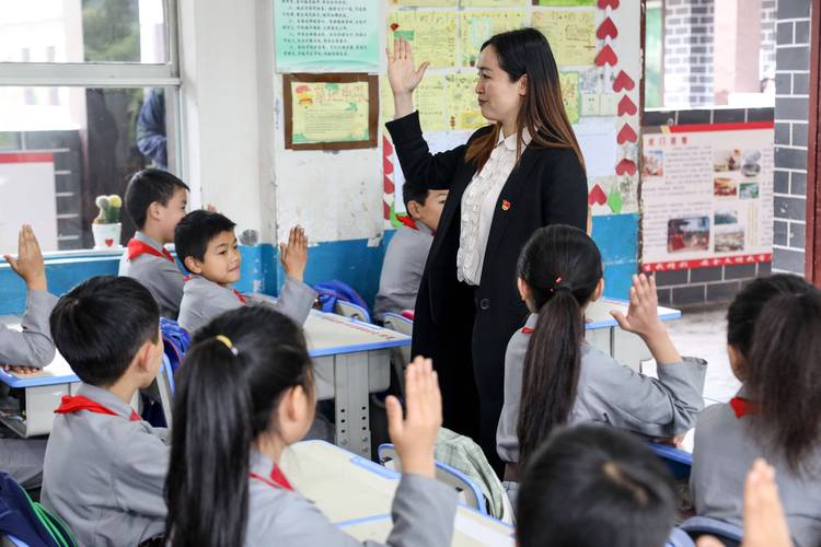 小学课堂上老师叫学生站起来回答问题学生局促攥衣角的画面