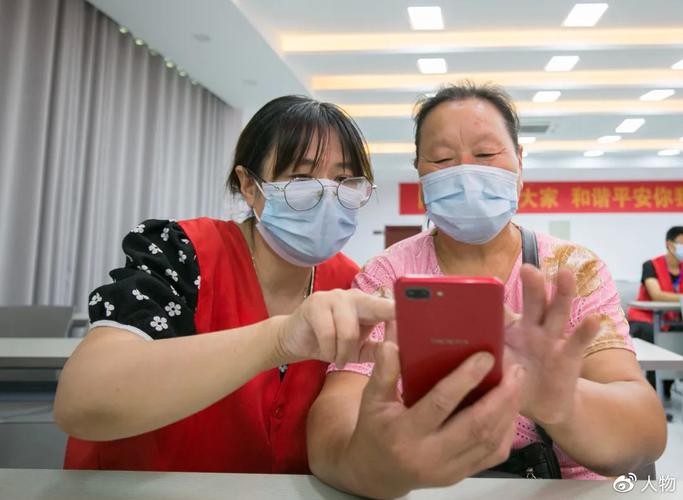 老年用户在社区志愿者协助下操作手机健康码界面