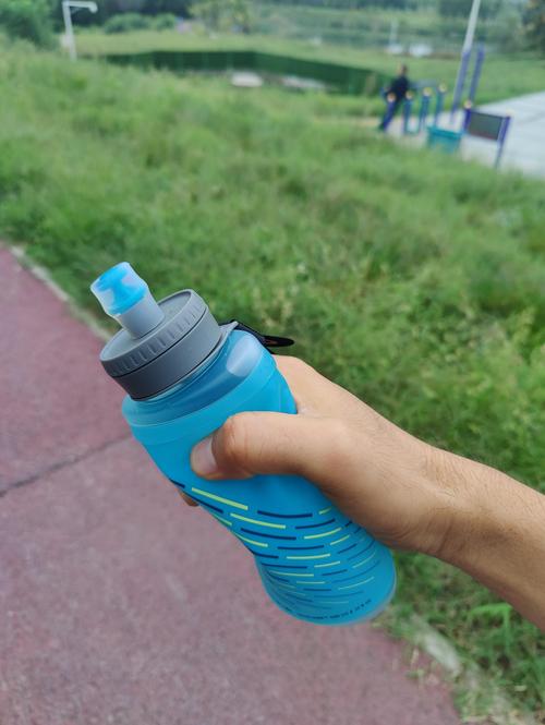 跑步者手持运动水壶喝水