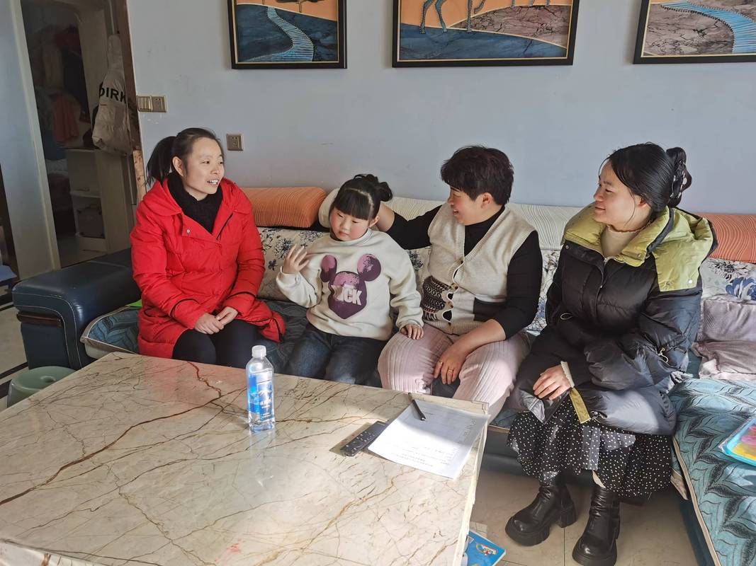 老师通过平板电脑与留守儿童家长进行视频家访的画面
