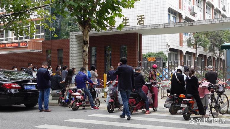 小学傍晚辅导班门口家长换书包场景