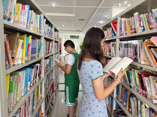 初中生在图书馆书架前选书的侧影