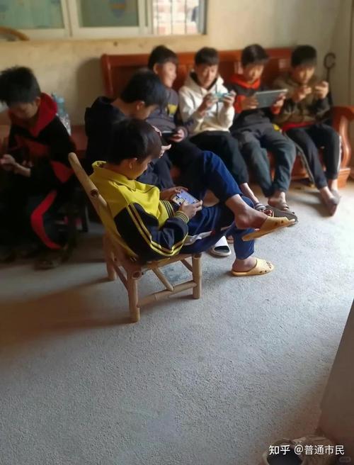 西部农村孩子在昏暗的房间里用手机上网课