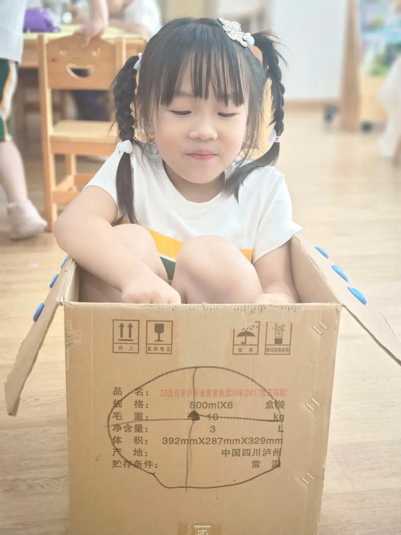 孩子快乐地钻进纸箱玩耍而非昂贵玩具的场景
