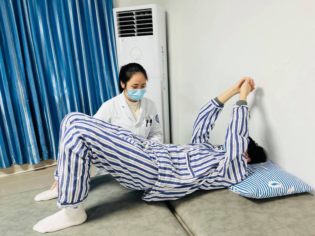 康复科医师帮助中风患者穿戴行走外骨骼训练