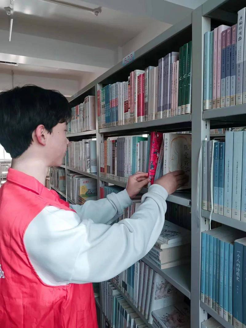 大学生在图书馆借阅行业就业指导书籍的侧面特写