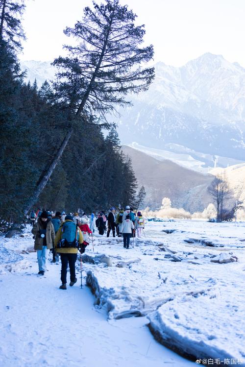 高原雪山脚下游客慢步行走照片