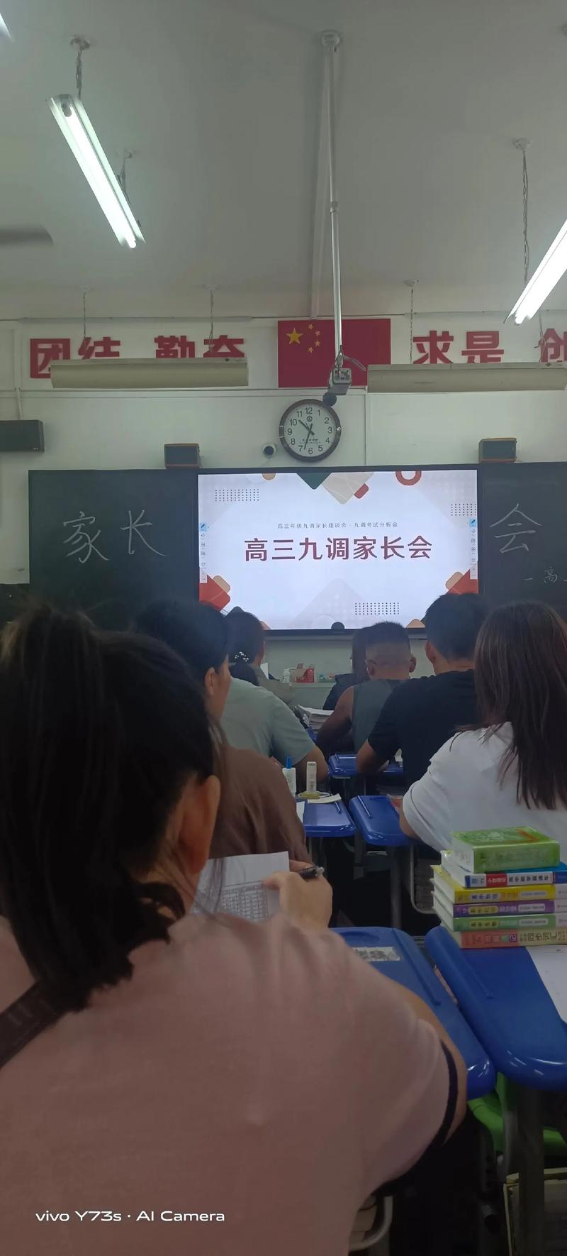 父亲神情落寞地坐在教室后排参加家长会