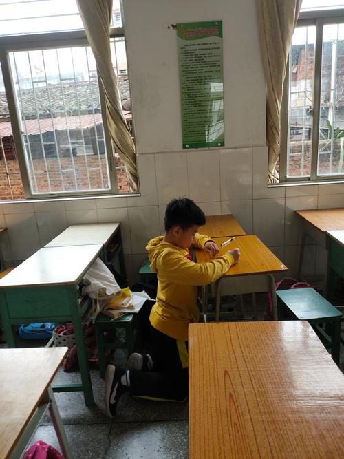 小学教室课间独自趴在走廊栏杆上的小学生