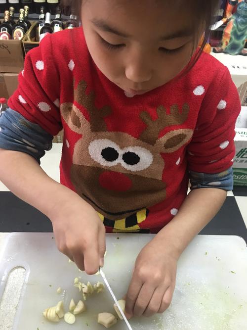 小学家庭晚餐孩子帮忙剥蒜场景