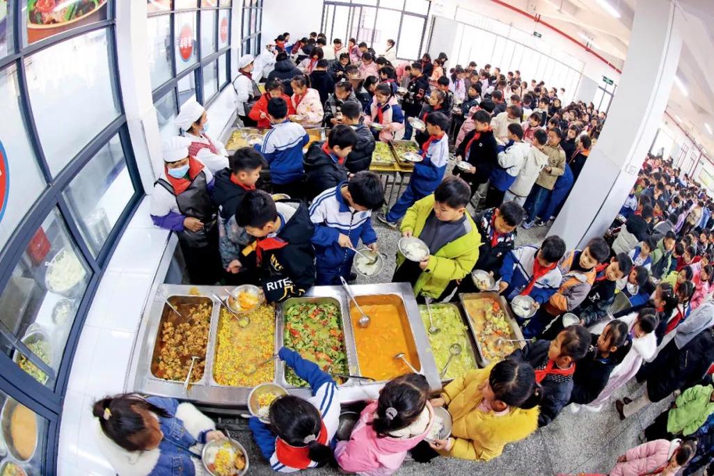 农村小学营养餐学生排队打饭场景