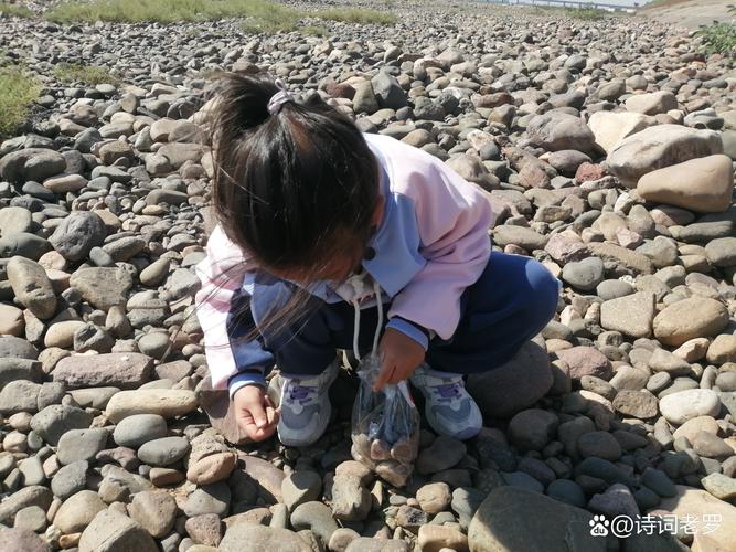 宝妈和孩子在河滩观察河床地形地貌捡石头