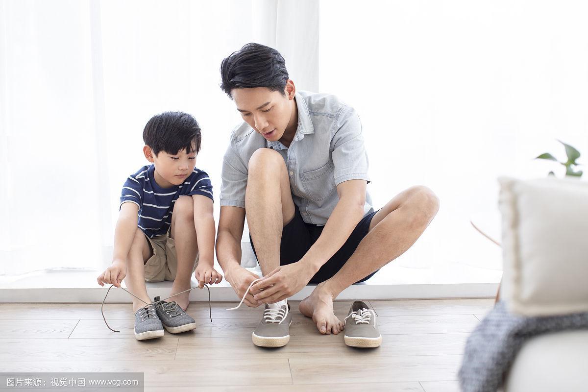 父母耐心教年幼孩子系鞋带的温馨场景