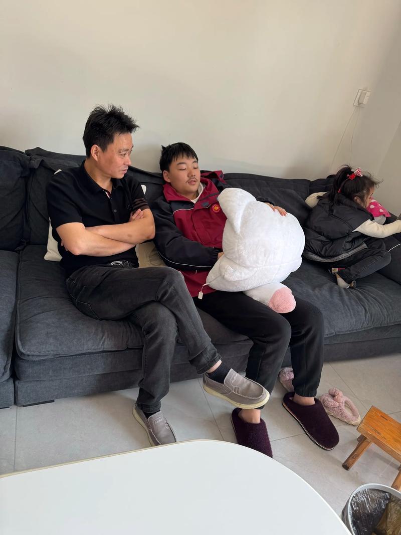 父亲与儿子在沙发上对视的特写,温馨家庭场景
