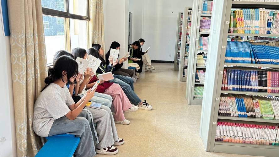 老师与学生在图书馆地板上围坐讨论群文书目