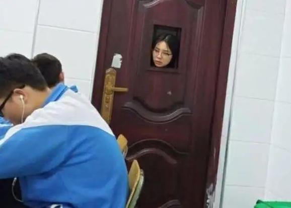 小学班主任傍晚在老旧居民楼楼道敲学生家门的场景