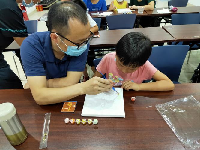幼儿在绘画过程中主动向家长展示自己涂鸦作品的互动场景