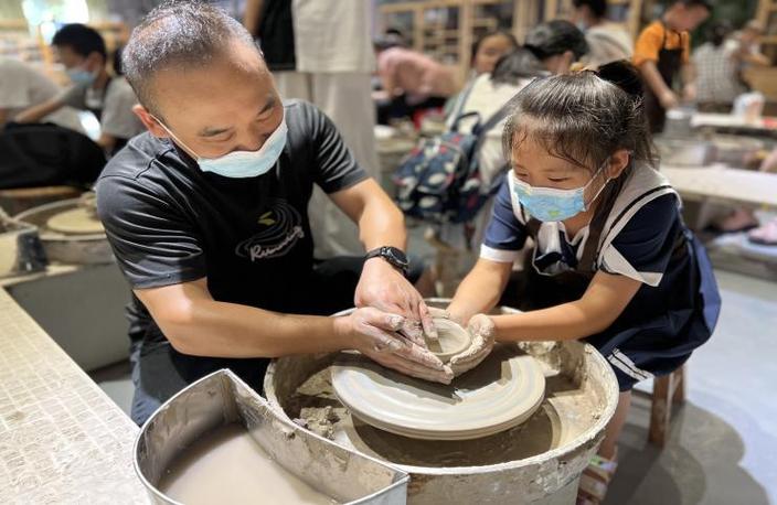 亲子陶艺工作坊中孩子与家长共同拉坯