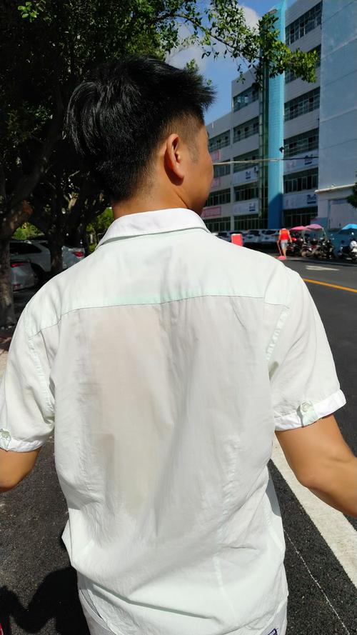 三伏天户外行走后衬衫被汗水浸湿的年轻人