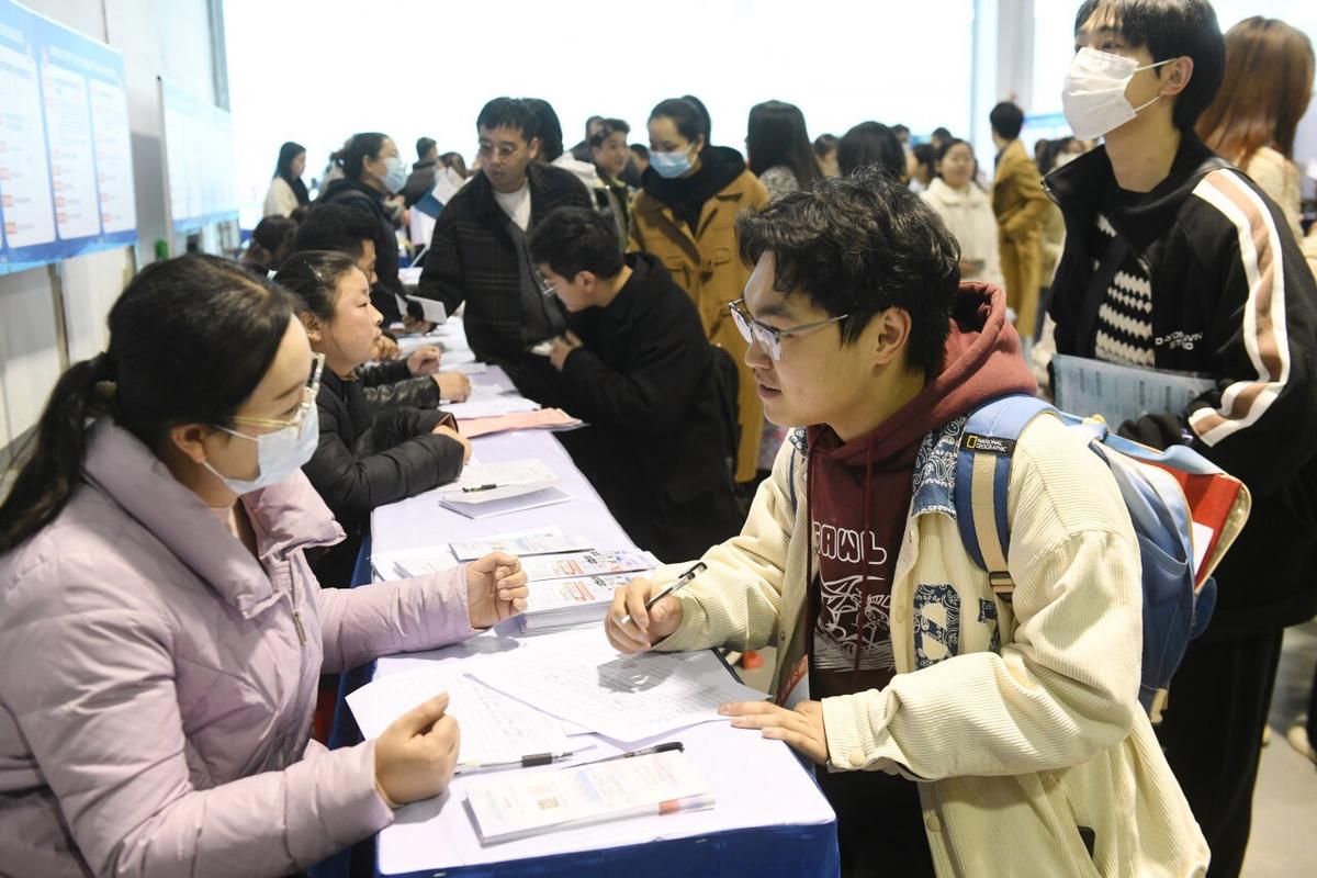 招聘会现场求职者与面试官面对面激烈讨论的瞬间