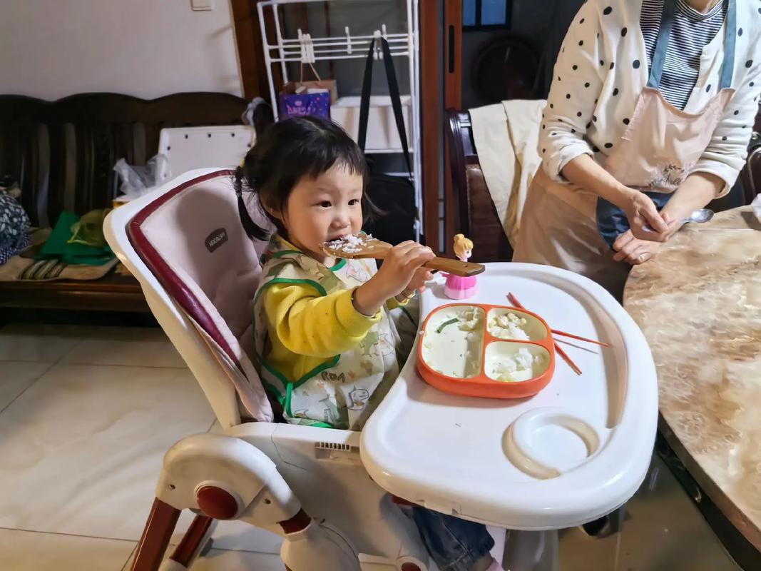 2岁宝宝骑扭扭车绕餐桌 餐椅上撒着辅食碎的居家场景