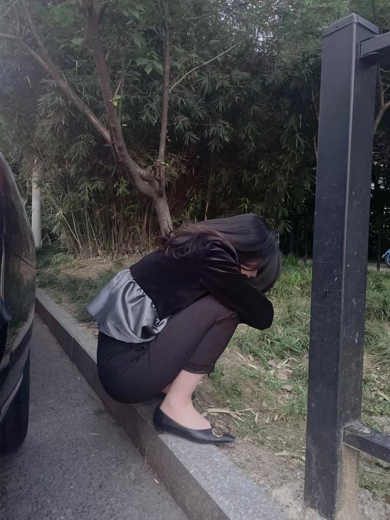 法院门口路边蹲着休息的年轻女人