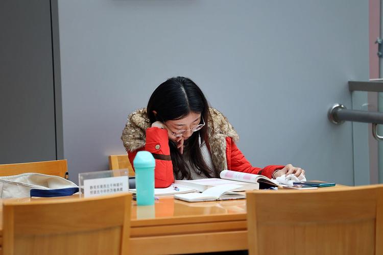 办公室窗边改作业的青年教师