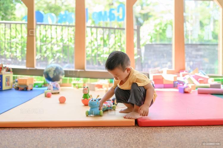 孩子独自蹲在幼儿园角落玩玩具