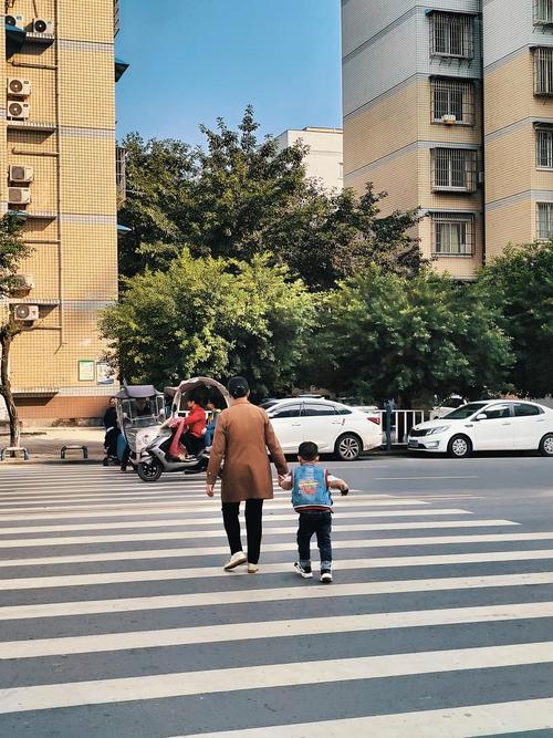 城市路口斑马线红灯旁祖孙等待背影