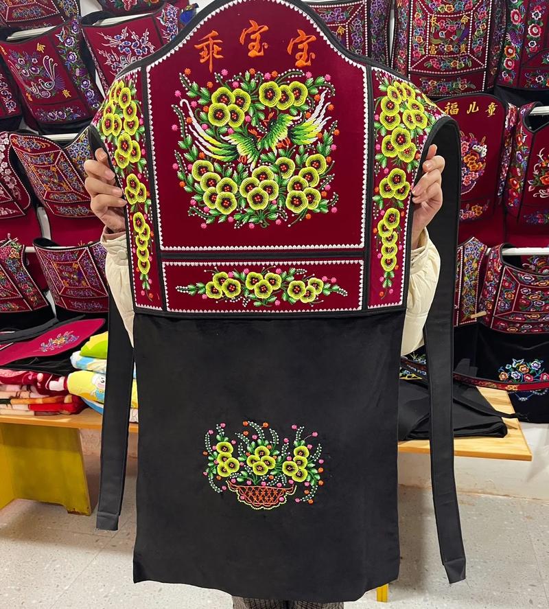 侗族母亲用绣花背带背孩子劳作