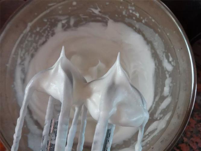 打蛋器提起呈现硬性发泡的蛋白霜尖角特写