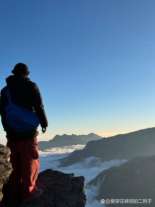 一个人站在悬崖边看着远方落日,背包上写着“职业转型”
