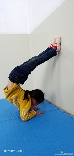 小学走廊拐角靠墙压腿的胖小男孩
