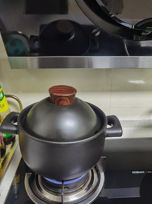 厨房灶台上正在慢炖的砂锅冒着热气
