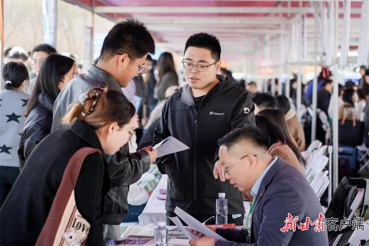 高校毕业生在公益性岗位政策咨询展位前了解信息