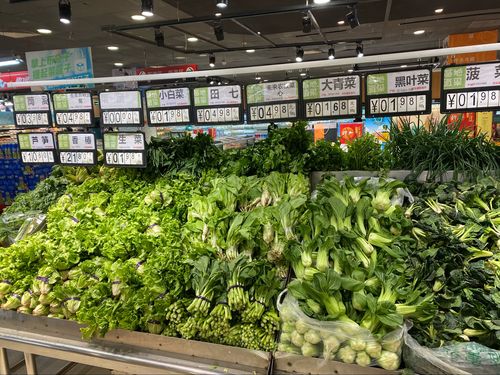超市闭店前贴黄色折扣签的叶菜货架实拍
