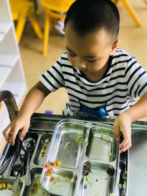 幼儿自己拿勺子吃饭弄脏餐桌场景图