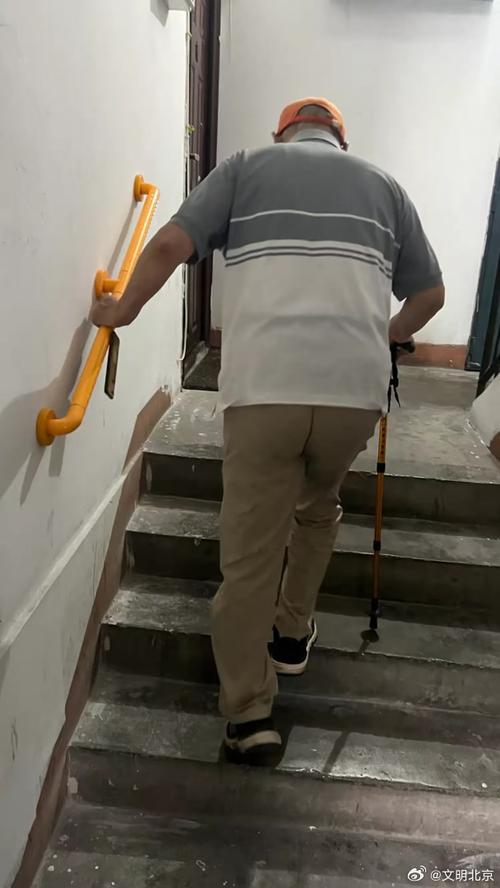 居民楼楼梯扶手旁普通人搭手慢走的实拍