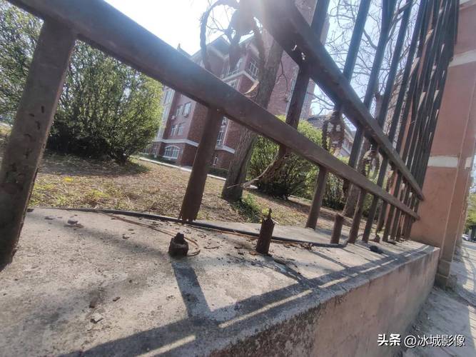 锈蚀铁艺栅栏在旧街区转角处的细节