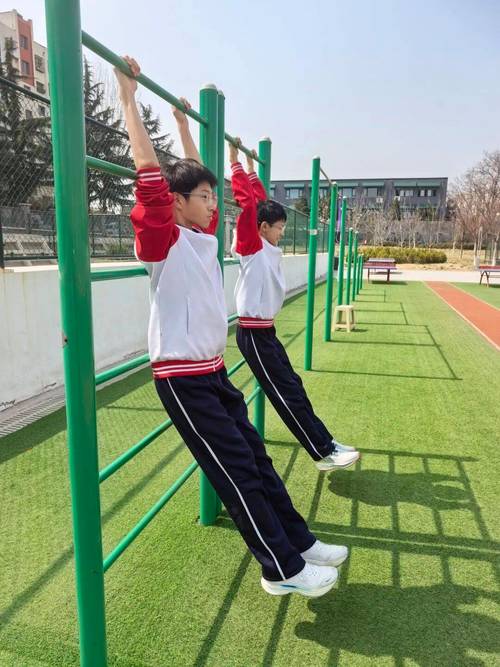 初中生在学校操场练习引体向上实拍