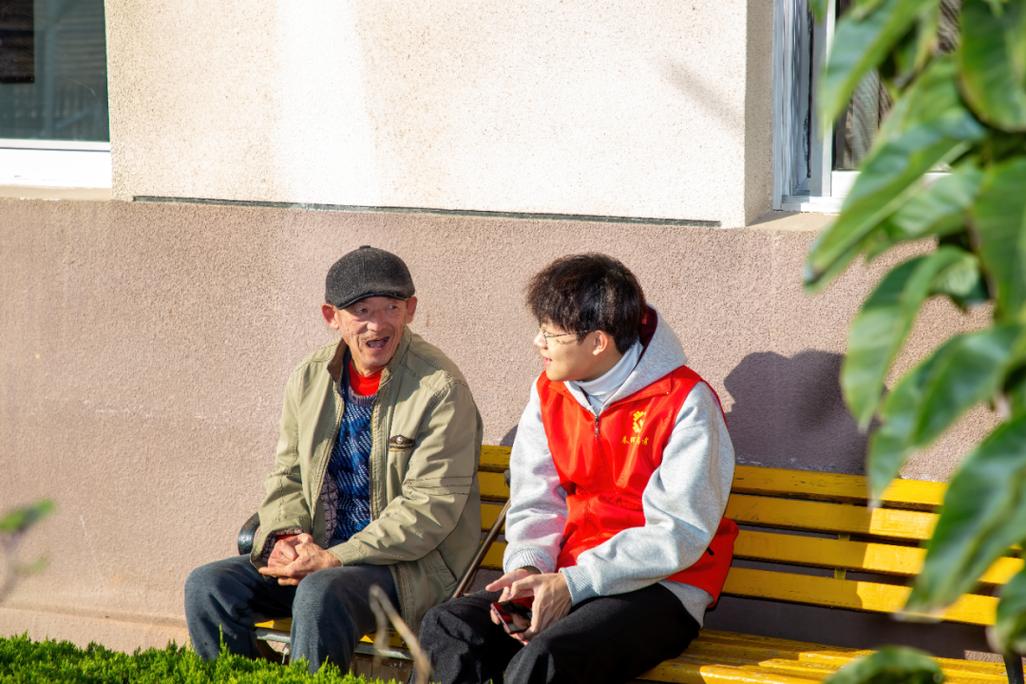 管理者和员工并肩坐在园区长椅上聊天的场景