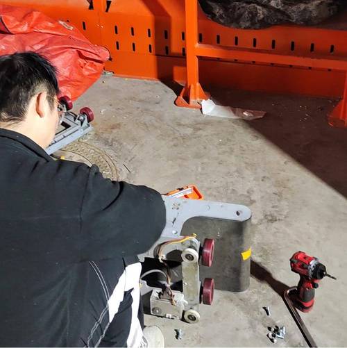分拣系统现场维保人员正在检查光电传感器支架,特写紧固件