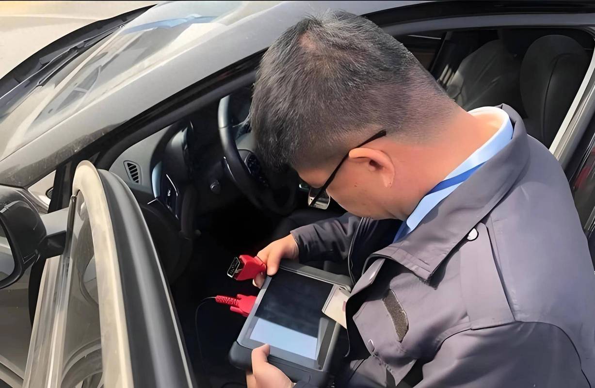 汽修技师手持OBD检测仪读取车辆数据流特写