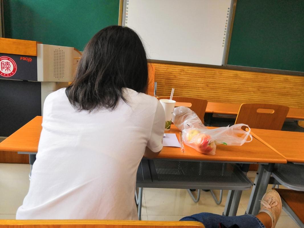 早读课老师给趴在桌上哭的学生递纸巾的侧影抓拍