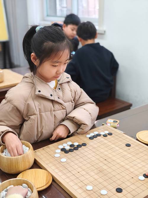 孩子坐在地板上思考围棋落子特写