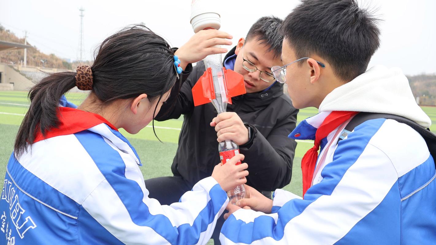 一群小学生围观简单的水火箭发射实验