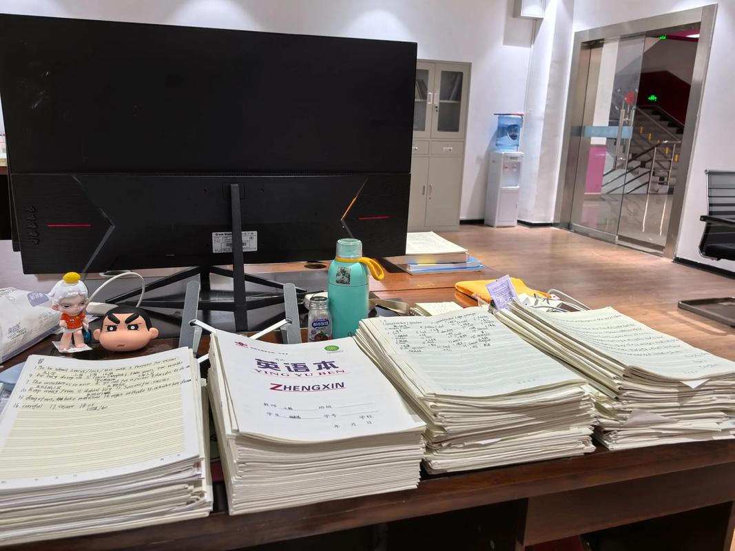 疲惫的小学老师在办公室批改堆积如山的作业