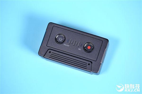 2030年代出租屋桌面旧录音笔与半凉的橘子水