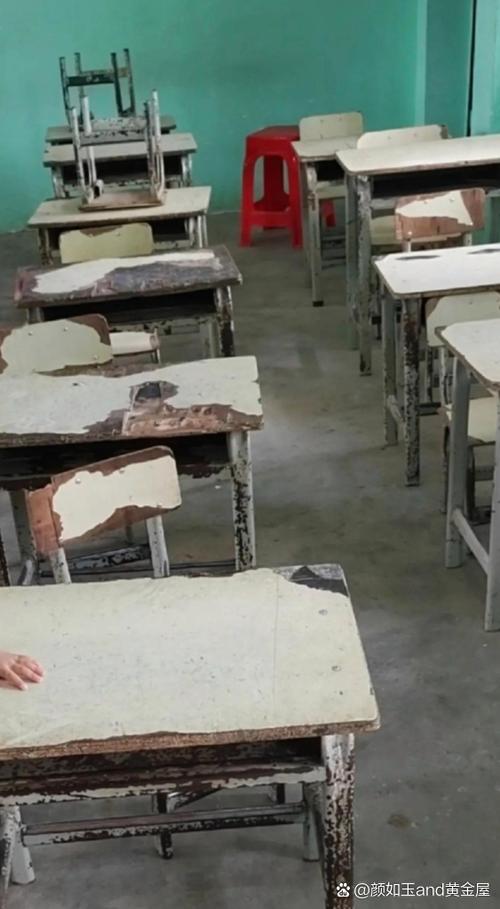 湘西山区破旧农村小学教室孩子坐在磨损课桌旁